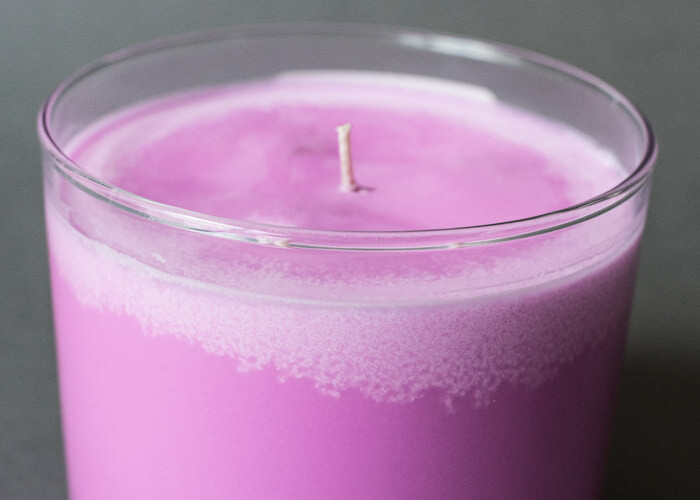 Candle with soy wax frosting around the top edge of the glass container.