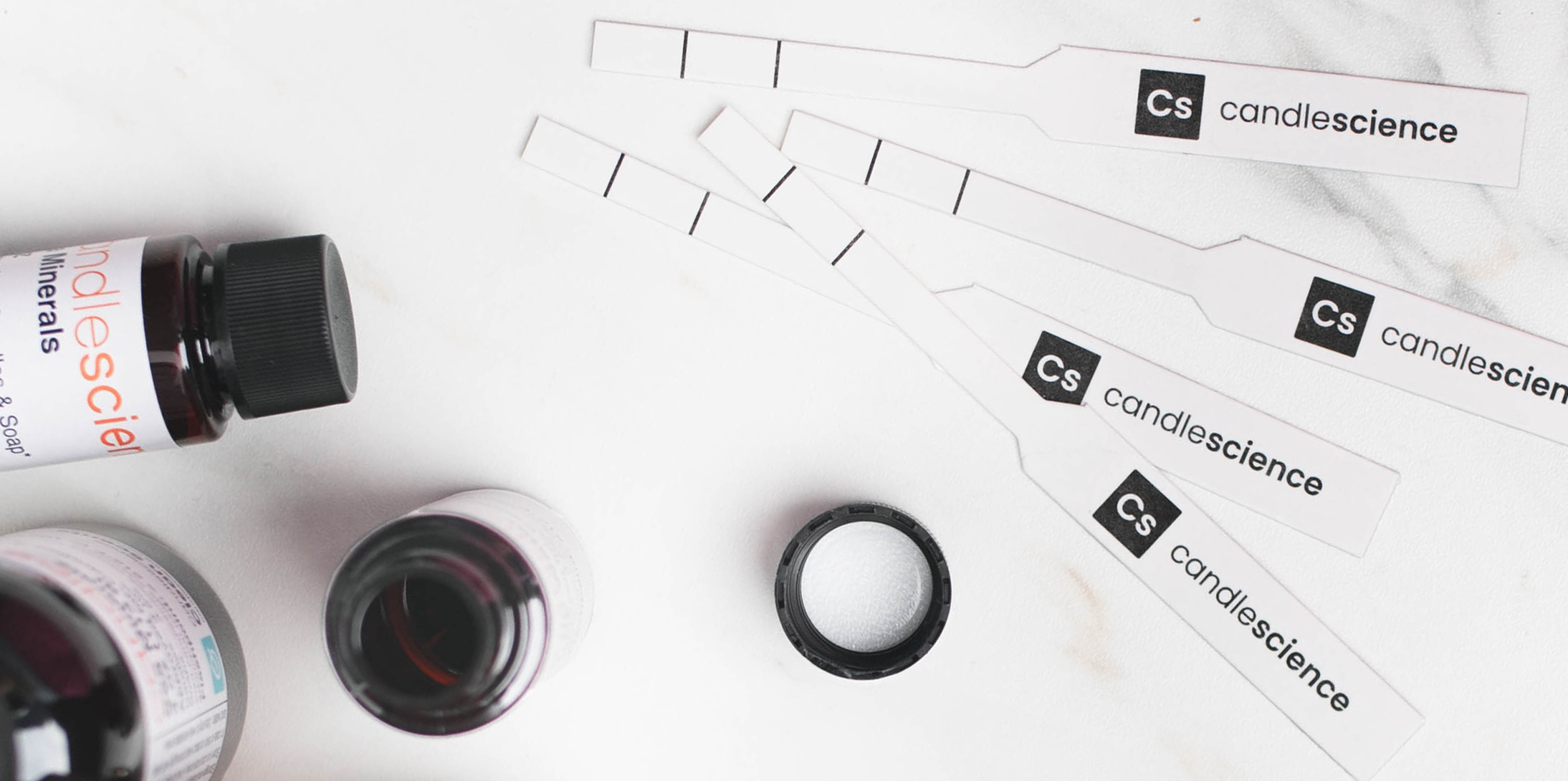 A 1 oz bottle of Sandalwood and a 1 oz bottle of Black Sea with two fragrance blotter strips